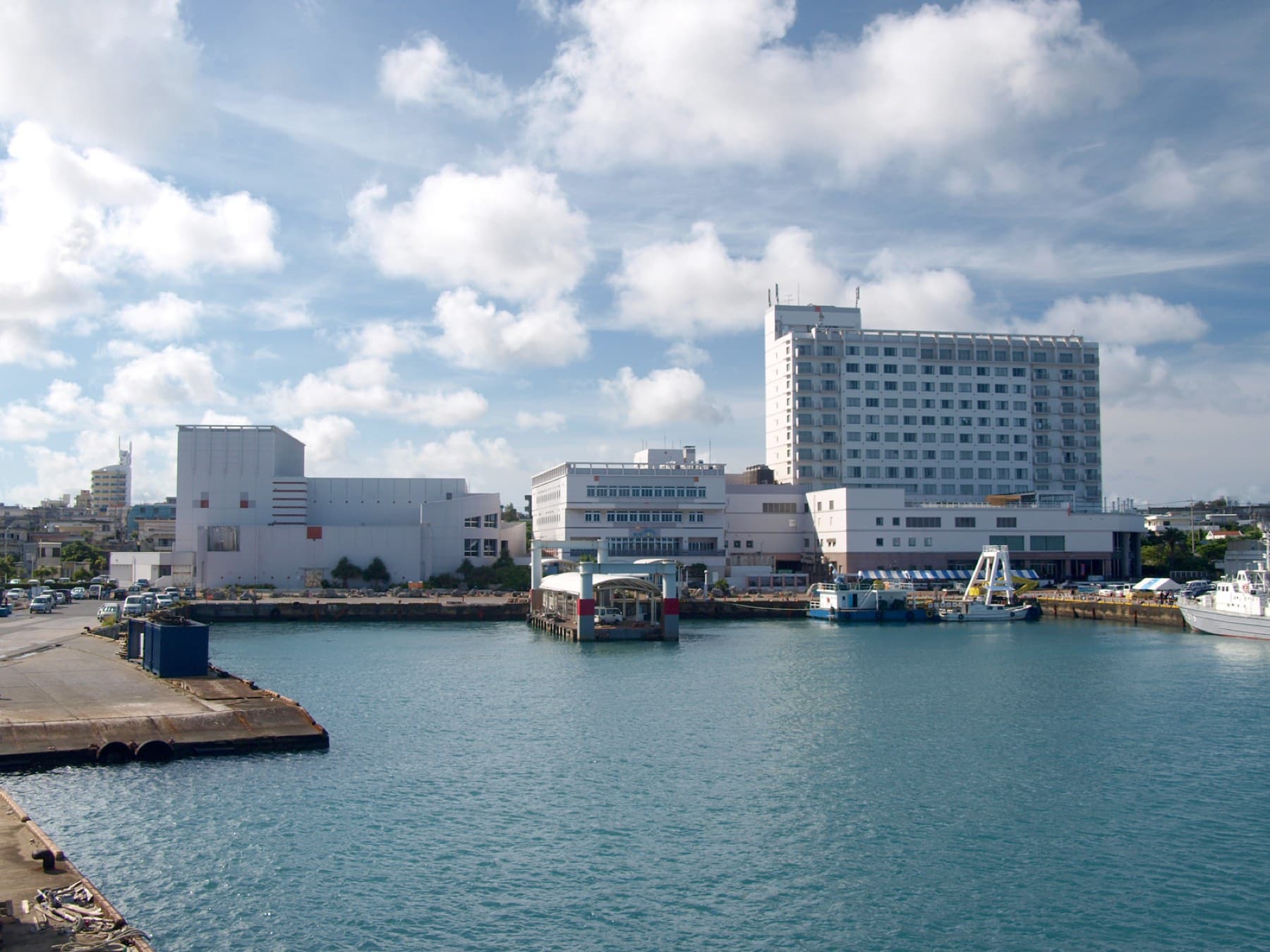 The quay of Hirara Port looks across calm harbour water to the hotels and terminal buildings of Miyako's main town.