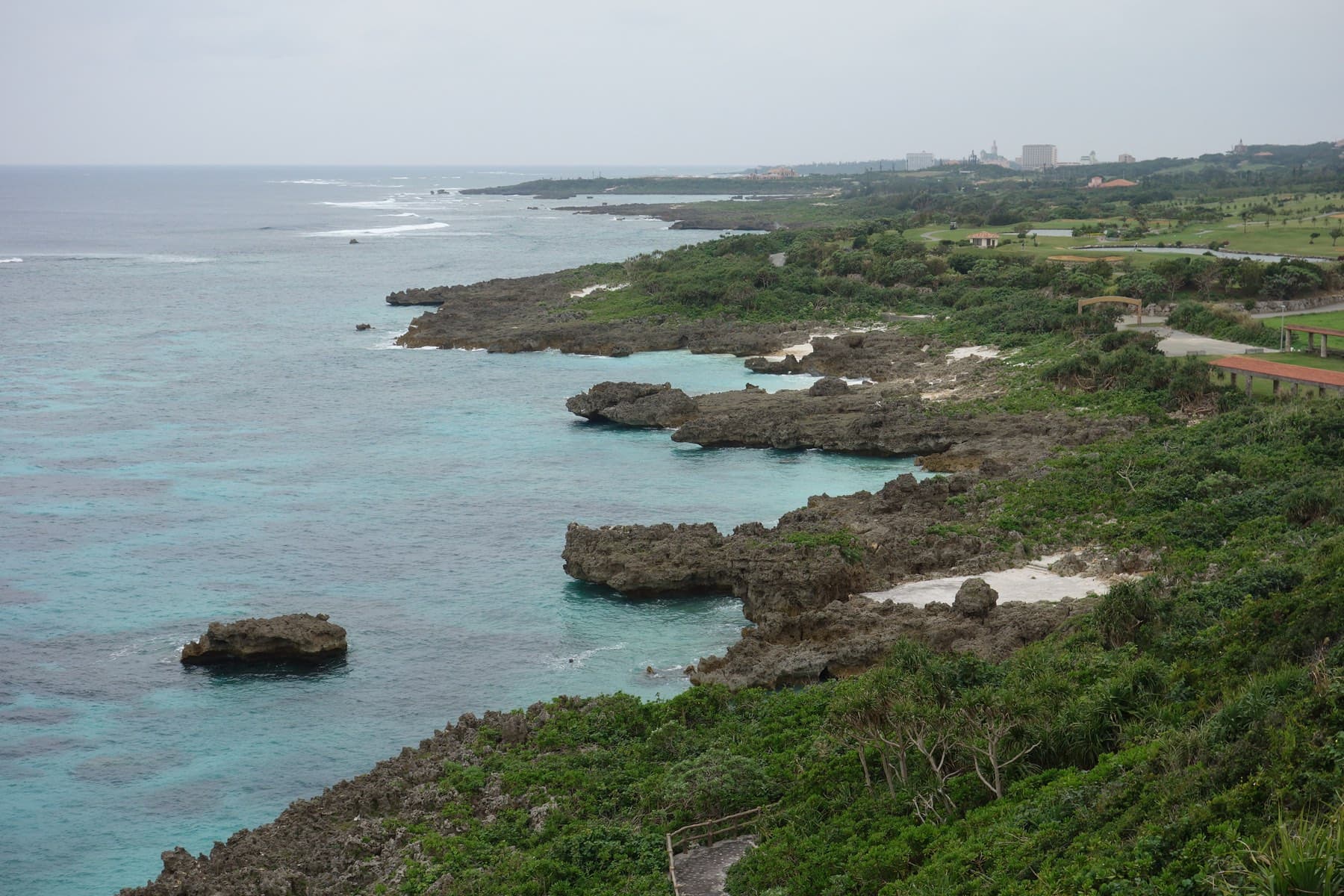 The lookout above Imgya Marine Garden looks down on fingers of dark limestone reaching into clear green water along the coast.