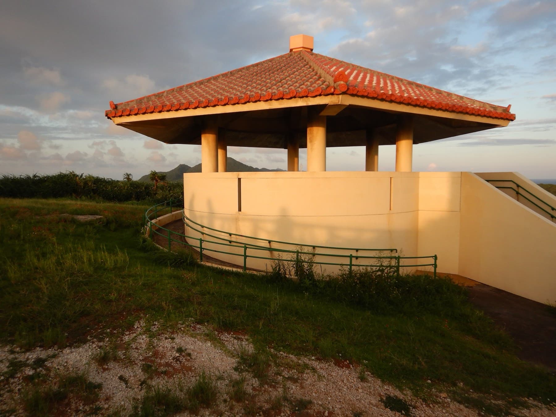Late sun warms the red-tiled pavilion at Irizaki, the westernmost point of Japan, as the grass around it falls into shadow.