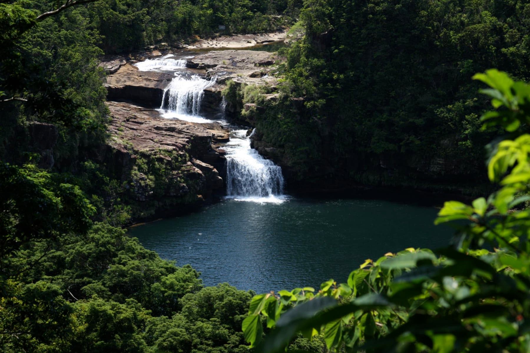 Mariyudu Falls drops in two broad tiers into a dark round pool surrounded by thick forest on the upper Urauchi River.