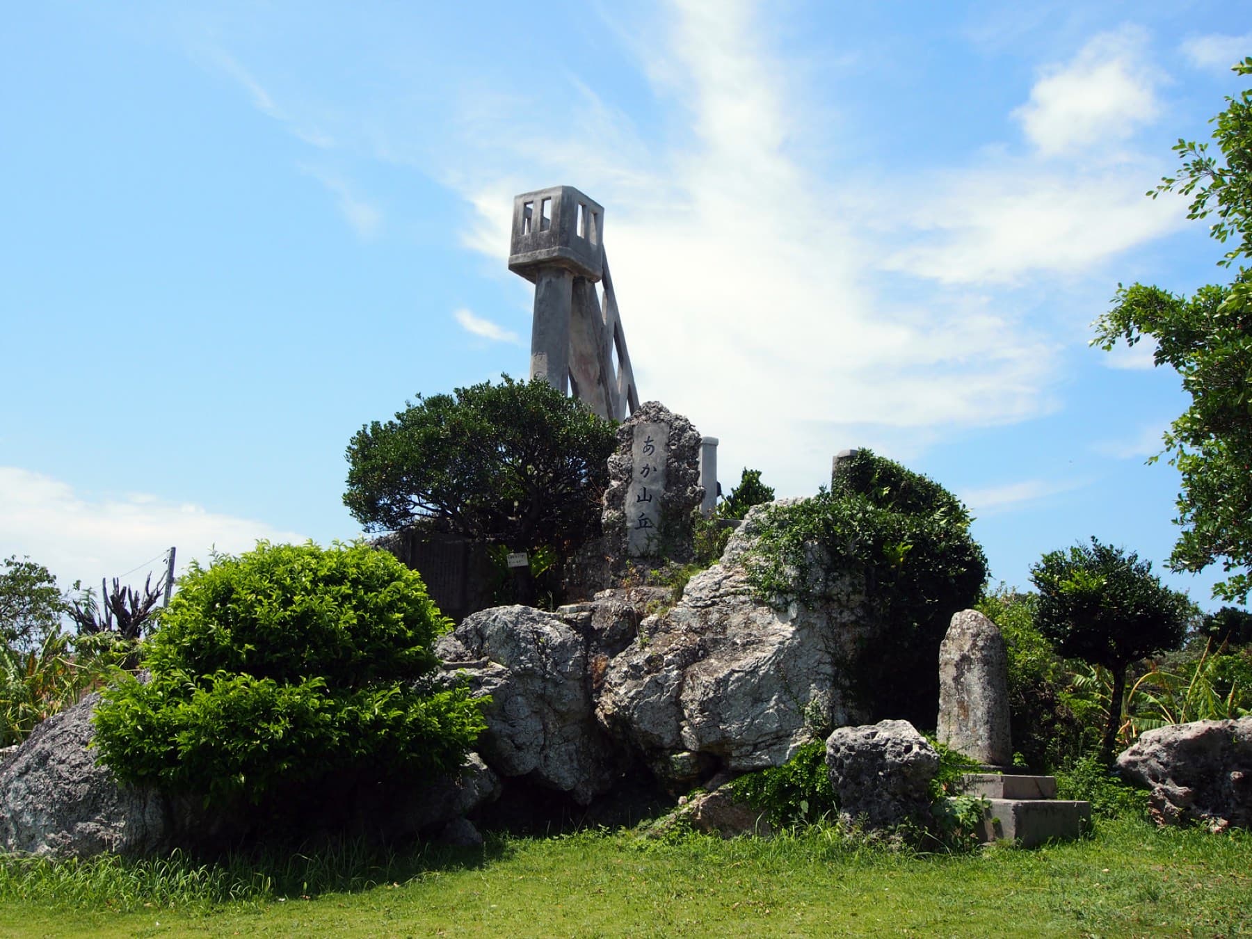 The narrow concrete lookout of Nagomi-no-to stands on a mound of coral rock and shrubs in the middle of Taketomi village.