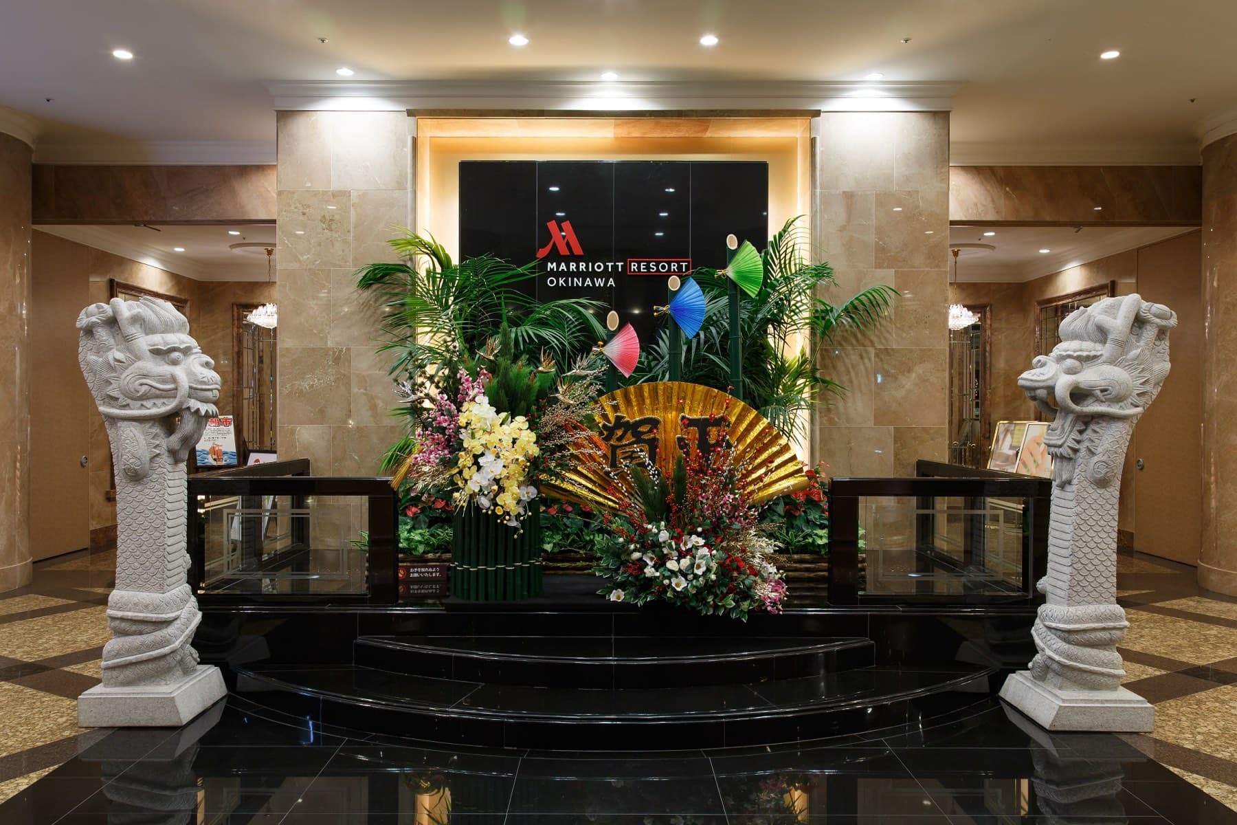 Stone dragon pillars flank a New Year flower display in the marble lobby of the hotel at Kise in Nago.