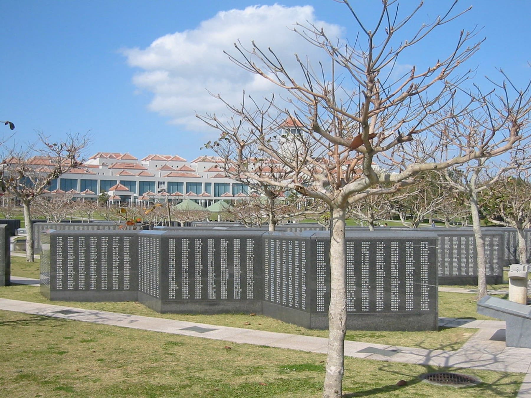 Black granite walls of the Cornerstone of Peace, carved with the names of everyone who died in the Battle of Okinawa, stand in rows between bare trees