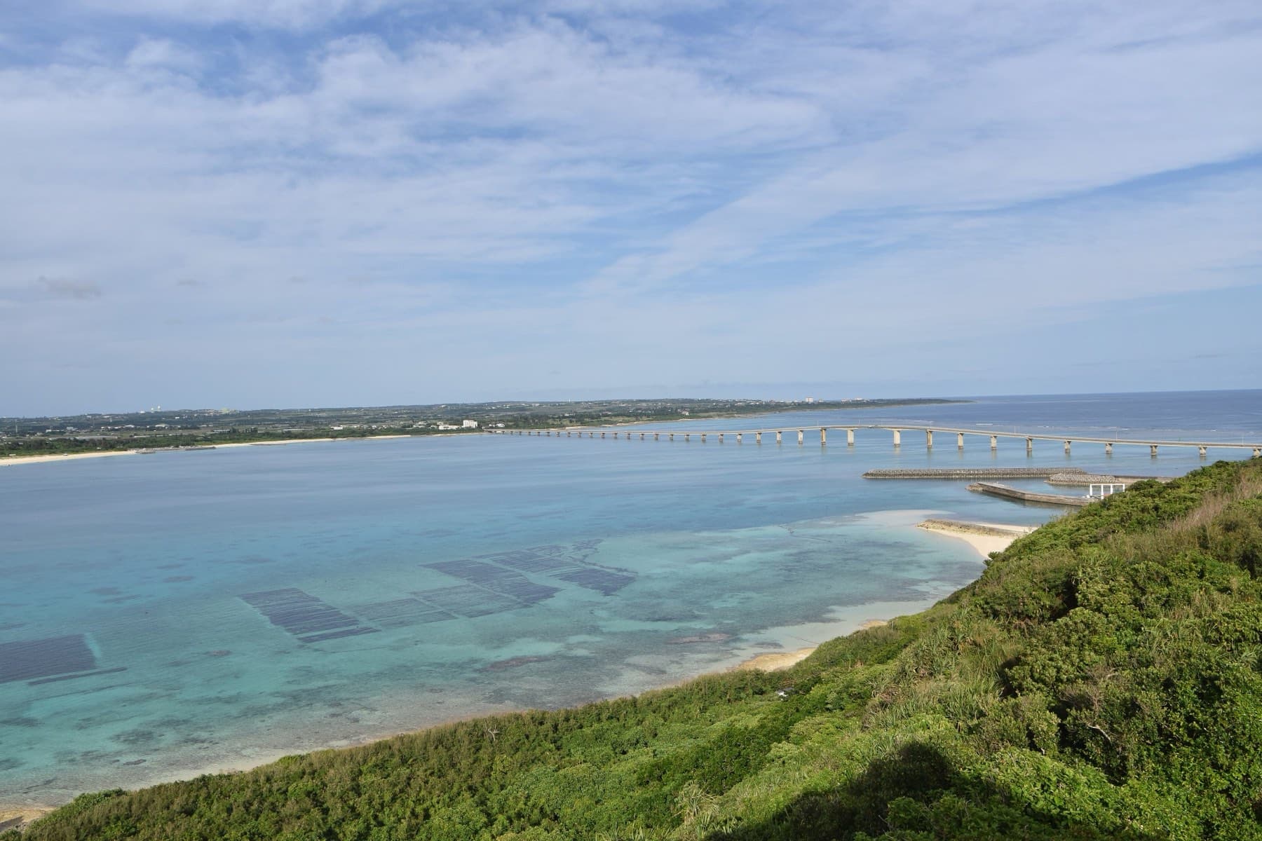 The top of the Ryugu-jo Observatory on Kurima looks over scrub and reef shallows to the Kurima Bridge and the long beach of Yonaha Maehama.