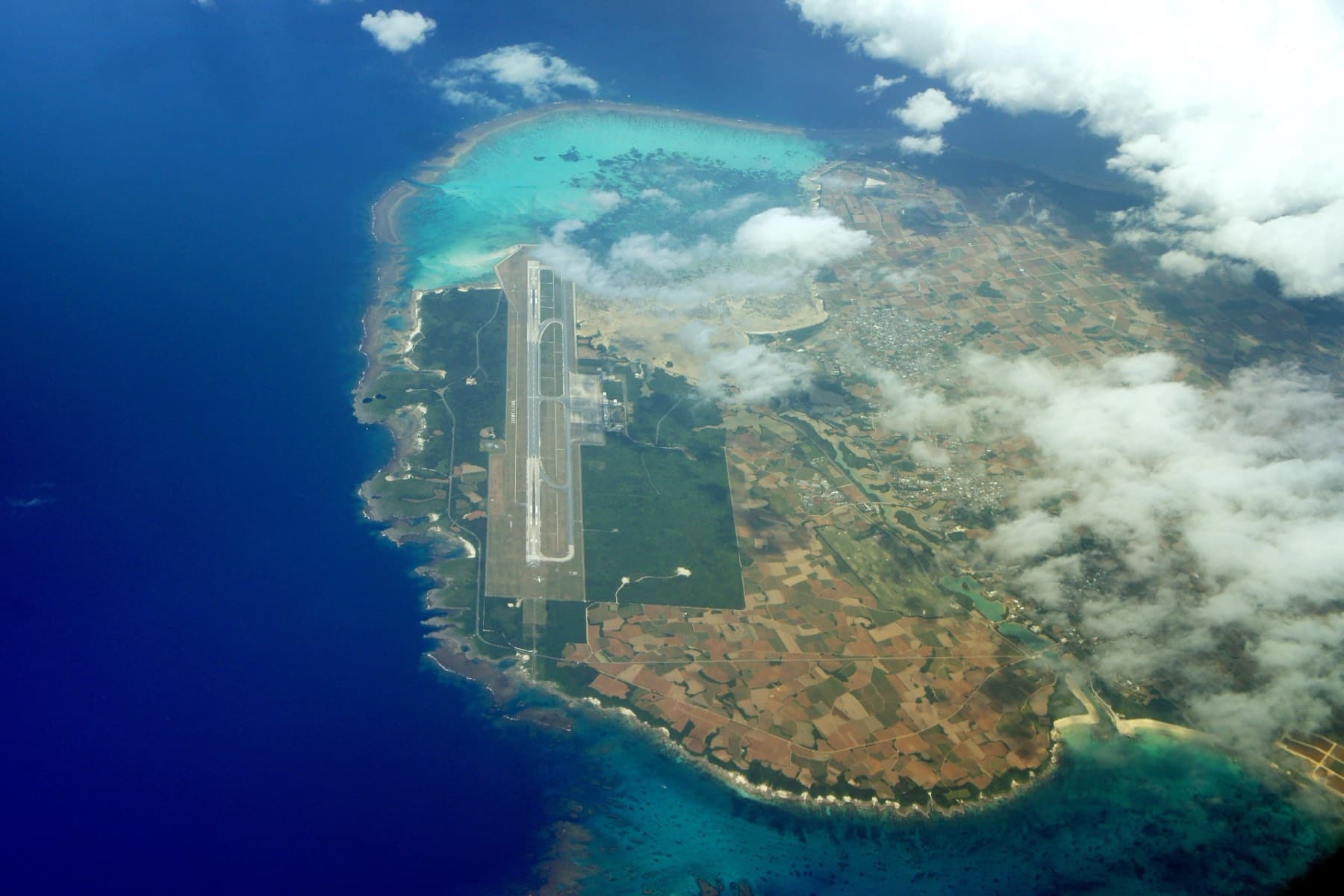 Seen from an aircraft, the long runway of Shimojishima Airport runs the length of Shimoji between its reef edge and the farmland of Irabu.