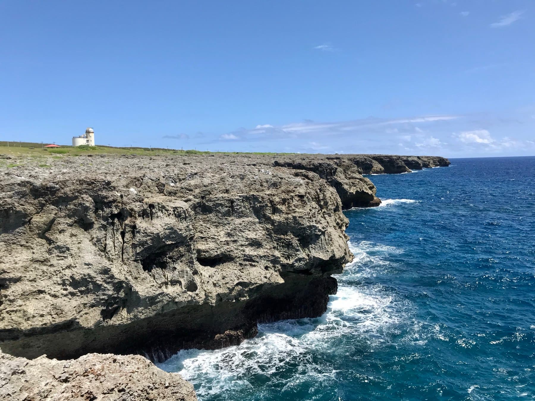 The rugged limestone shelf of Takanasaki runs along the south coast of Hateruma with the star observatory standing on the skyline.